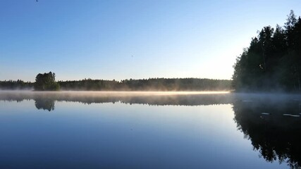 Wall Mural - scene of foggy lake. mist moving along water surface in morning sun lights, beautiful nature backgro