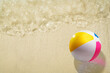 © Leo Lintang - Aerial view of colorful beach ball on a beautiful sandy beach under clean and transparent blue ocean waves. Natural background. Summer concept