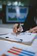 © Kieng - A professional businesswoman calculates financial data using a calculator, surrounded by charts and reports, analyzing company performance to ensure growth, profitability, and strategic business decis