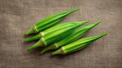 Fototapete - Fresh okra pods in an overhead layout on burlap fabric with natural light and ample space