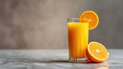 Fototapete - Glass of orange juice with fresh slices beside it on a marble counter, leaving room for layout