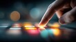 © The Little Hut - Close-up of a person's finger pressing colorful illuminated buttons on a digital control panel or electronic device at night