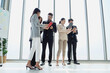 © AU USAnakul - Multicultural business team holding coffee cups while having casual conversation at work, representing modern professional culture and interpersonal connection.
