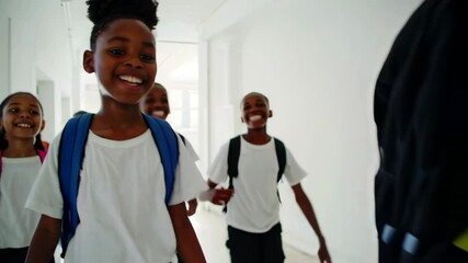 Leinwandbilder - Elementary school multi ethnic pupils wearing colorful backpacks walking together happily along bright school hallway, showcasing childhood friendship and learning enthusiasm