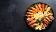 © Afif Amrullah - A delectable seafood platter featuring grilled prawns, mussels, and lemon wedges, artfully arranged on a dark tray.