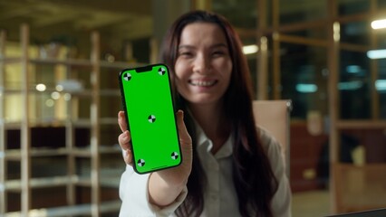 Happy business woman Asian girl browsing mobile phone green screen copy space Chinese businesswoman showing empty display chroma key Korean Japanese joyful excited female user online smartphone app