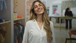 © Krakenimages.com - Blonde smiling woman in white blouse blows a kiss with hands to lips in boutique; affection playfulness.