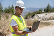 © ADDICTIVE STOCK - Engineer inspecting wind turbines with a laptop outdoors