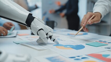 Poster - A futuristic scene of a robotic hand assisting a human in analyzing colorful charts and graphs on a table, representing the collaboration between technology and human effort.Noogenesis