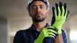 © David Zarzosa - Construction worker putting on the gloves and hard hat preparing for work at construction site.