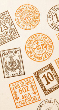 Close-up of various brown and orange passport stamps on beige paper background, showcasing travel and adventure concept