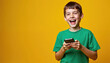 © Viktor - Joyful young boy with smartphone, smiling, laughing with excitement against bright yellow background. Energetic youth engaged with modern digital technology, connecting with others, enjoying playful