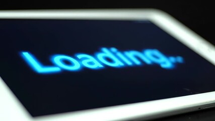 Poster - Blue Loading Text on a Tablet Screen with Dark Background and Blurred Edges