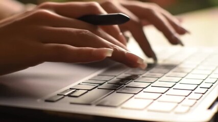 Poster - Close Up of Hands Typing on Silver Laptop Keyboard in Warm Light and Blurred Background
