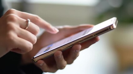 Poster - Person's Hand Using Touch Screen Mobile Device with White Screen Silver Ring on Finger and Gold Edges Phone