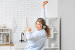 © Pixel-Shot - Young woman in headphones dancing at home