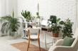 © Pixel-Shot - Interior of office with workplace, shelf unit and green plants