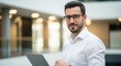© MstMorjina - Photo of confident businessman with laptop in modern office environment