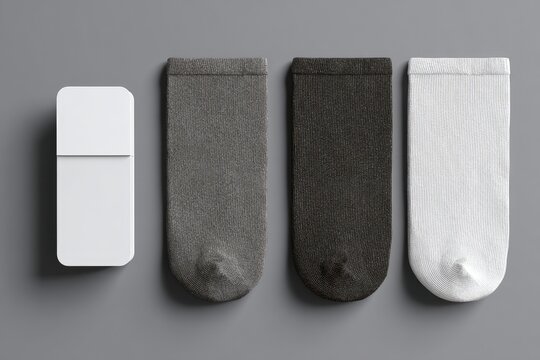 Three pairs of folded socks in gray, dark gray, and white, displayed with a blank rectangular box