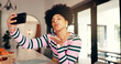 © peopleimages.com - Woman, blow kiss or selfie in home for social media, update blog or online connectivity. African influencer, photography or gesture in house for dating app interaction, follower engagement or contact