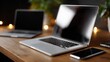 © DSimage - A sleek laptop and smartphone on a wooden desk, surrounded by warm lighting, creating a cozy and modern workspace ambiance.