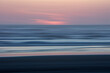 © Mint Images - Blurred motion abstract of ocean waves, beach and sky at dusk