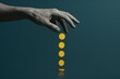 © Tanakorn - Hand dropping golden coins against a deep teal backdrop symbolizes financial investment, wealth creation, and the concept of minimalist abundance.