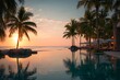 © Hammad - Beautiful sunset view over tranquil waters with palm trees at a tropical resort in golden light casting reflections.