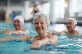 Group of elderly men and woman exercising in indoor swimming pool during water aerobics class