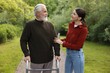 © New Africa - Caregiver supporting elderly man who using walking frame outdoors
