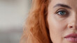 © Yuliia - Portrait half face cropped view Caucasian redhead woman looking at camera calm serious look health medicine feminism skincare girl female eyesight human perfect skin close up indoors domestic violence
