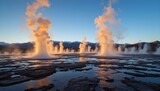 A breathtaking landscape of the El Tatio Geysers in northern Chile at sunrise, with golden light illuminating steam plumes rising from geothermal vents, Andes mountains in the background, and a clear 