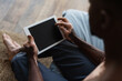 © Bliss - Cropped view of african american man with vitiligo using digital tablet with blank screen in bedroom