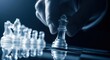 © Shihab - A hand moves the glass king chess piece on a chessboard in a strategic move