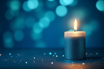 Poster - Silver candle burning brightly against a blurred blue background with glitter, creating a warm and inviting atmosphere