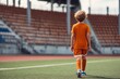 © LimeSky - Back view of a boy in sports gear heading toward the goal in a stadium