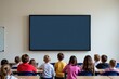 © yuntunen - Children watching a blank screen in a classroom setting