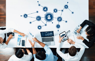 Poster - A diverse business team collaborates over a table, analyzing graphs and data visualizations while utilizing digital devices to improve financial strategies and insights. Amity