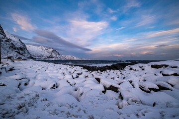 Wall Mural - Snowy Coastline with Mountains and Vibrant Sky