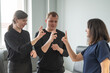 © Михаил Решетников - Caucasian woman teaching sign language to man and woman.