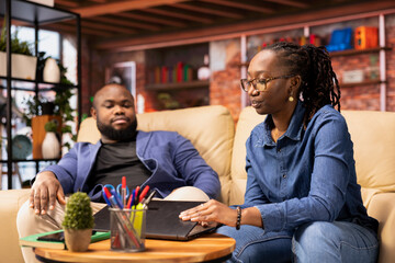 Poster - Freelancer at her home focused on online research and surfing the internet, utilizing a laptop for telework and staying connected in a digital world. Browsing social media on her couch.