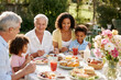 © HOT PLACE - Multicultural Family Having Breakfast Outdoors