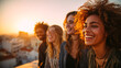 © Rubens - Four joyful young adults laughing together at sunset on a rooftop with city skyline