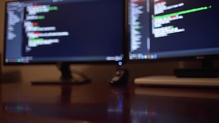 Poster - Blurred Dual Computer Monitors Displaying Code on Dark Wooden Desk in Office with Technology and Development Concept