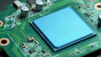 Poster - Close Up of a Green Circuit Board with Blue Processor Chip Under Bright Lighting