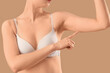 © Pixel-Shot - Beautiful young woman in underwear with arms cellulite problem on beige background