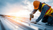 © Wararat - Construction worker wearing safety gear installing metal sheet roof under bright sunlight, focused on electric drill tool, detailed roofing structure, modern construction site