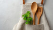© Sajib - Apron with wooden spoon and spatula along with fresh parsley in the pocket on white wall