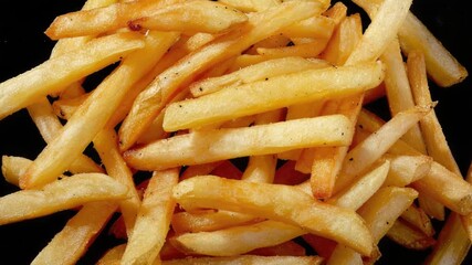 Aufkleber - A plate of French fries sitting on a dark background