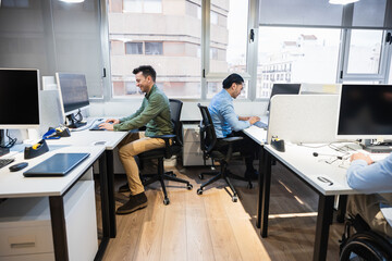 software developers coding at their desks in a vibrant, modern coworking office, focusing intently o